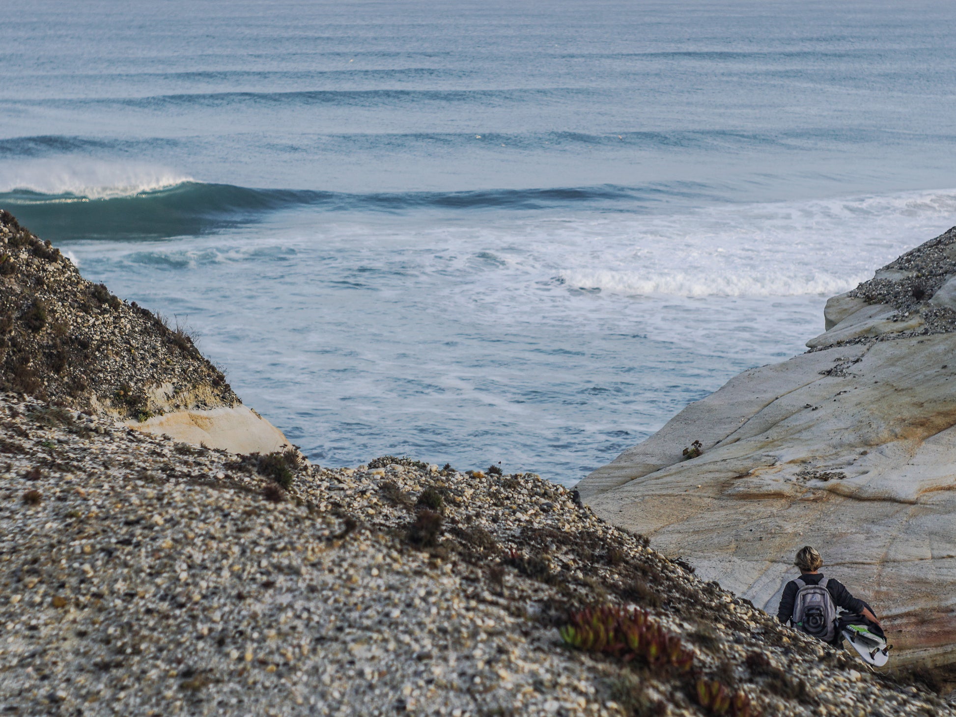 Beach in Peniche Portugal with perfect Waves, surfer walking holding a surfboard